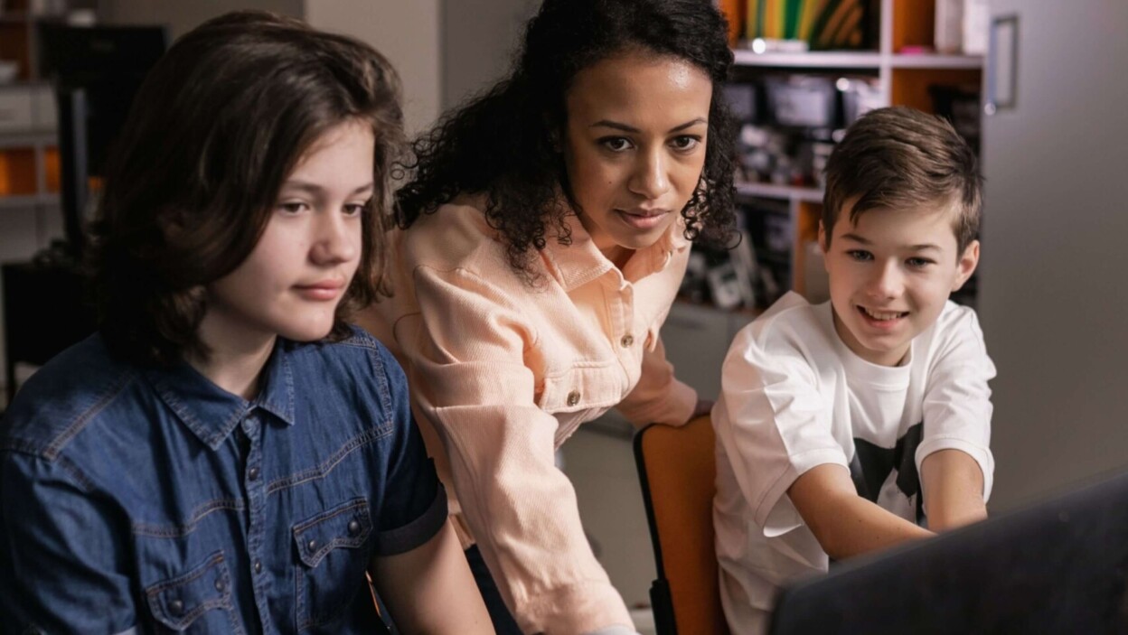 Une professeure de collège corrigeant des écrits sur ordinateur
