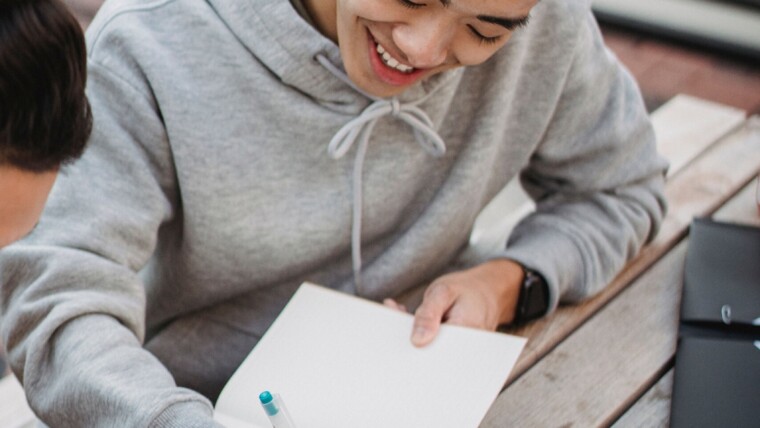 Un lycéen écrivant avec plaisir dans un carnet