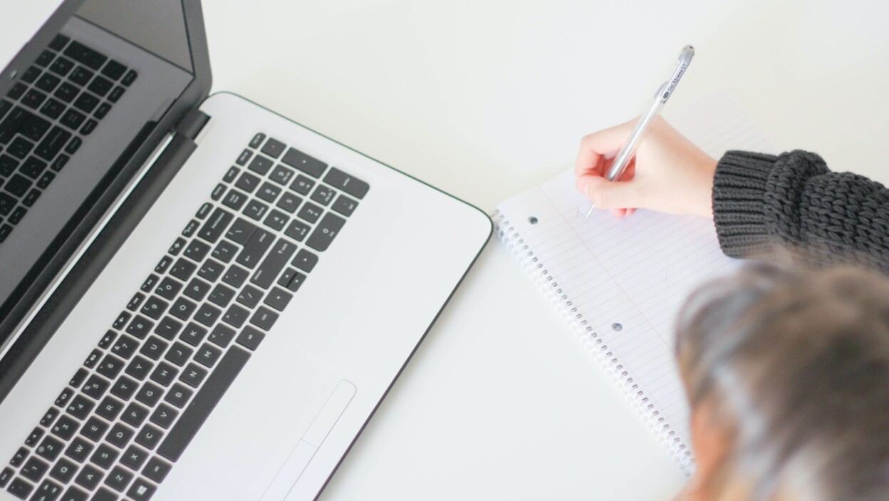 Un lycéen utilisant un ordinateur en classe pour travailler l'écriture