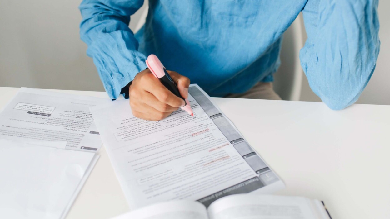 Un élève rédigeant un commentaire de texte au brouillon